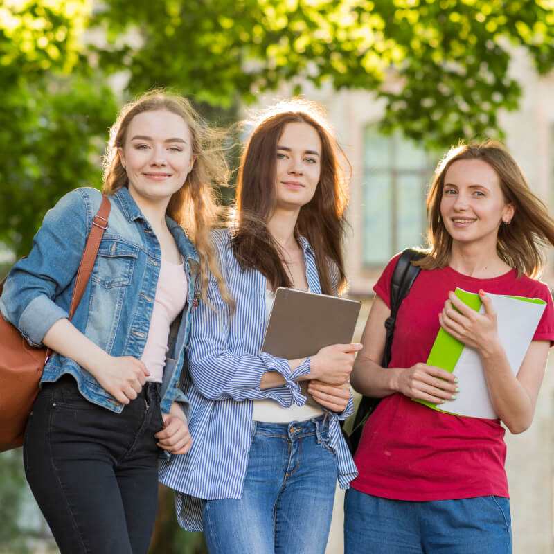 Students walking through a university campus with folders