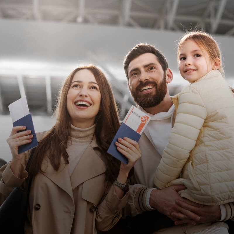 Family arriving at an airport holding passports and tickets